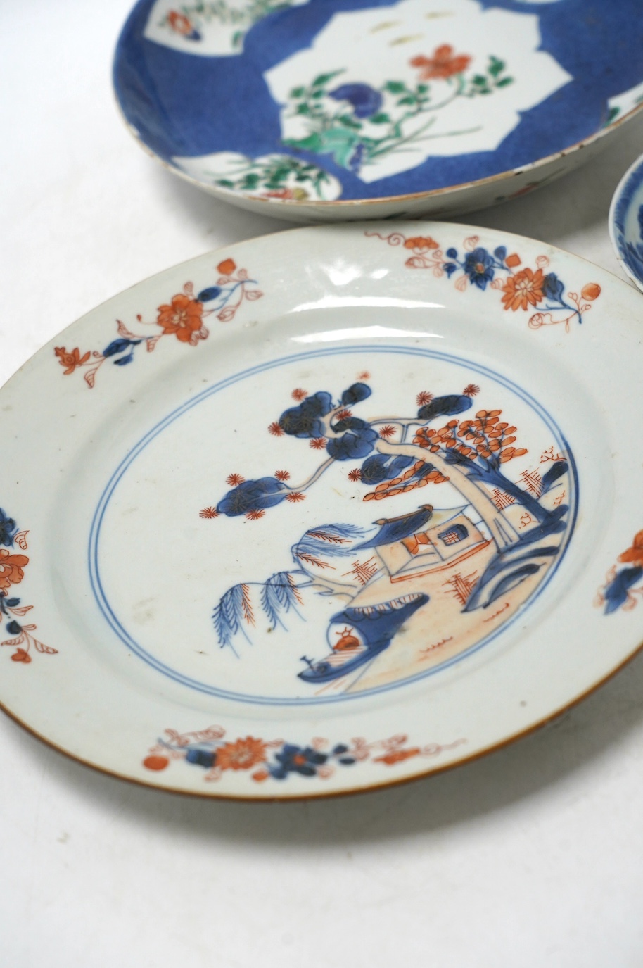 A Chinese powder blue famille verte dish, Kangxi period, a Yongzheng Imari plate and a Kangxi blue and white saucer, largest 22cm diameter. Condition - poor